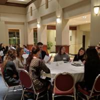 Students sitting at a table discussing their resume and cover letters at the Cover Letter and Resume Roundtable Event